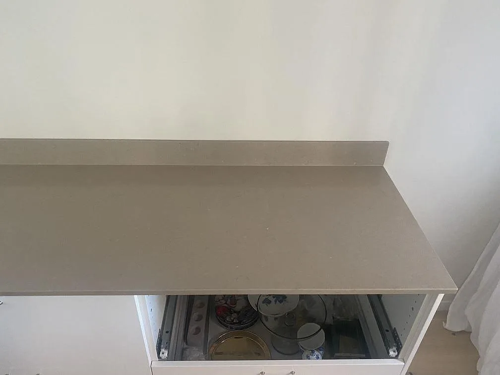 Köksbänkskiva i Silestone Coral Clay med uppvikt stänkkant och synlig kvartskomposityta i ett kök i Trelleborg.
