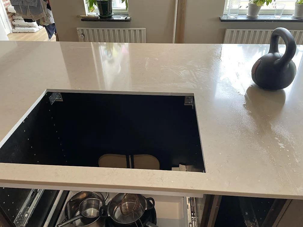 Polerad Silestone Coral Clay på köksö med hällöppning och synlig stenstruktur i ett kök i Trelleborg.