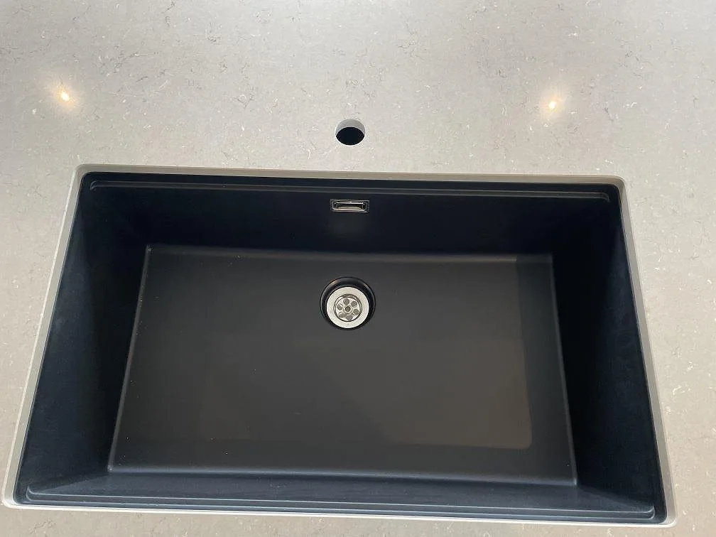 Svart underlimmad diskho i köksbänkskiva av polerad Silestone Coral Clay i Trelleborg.
