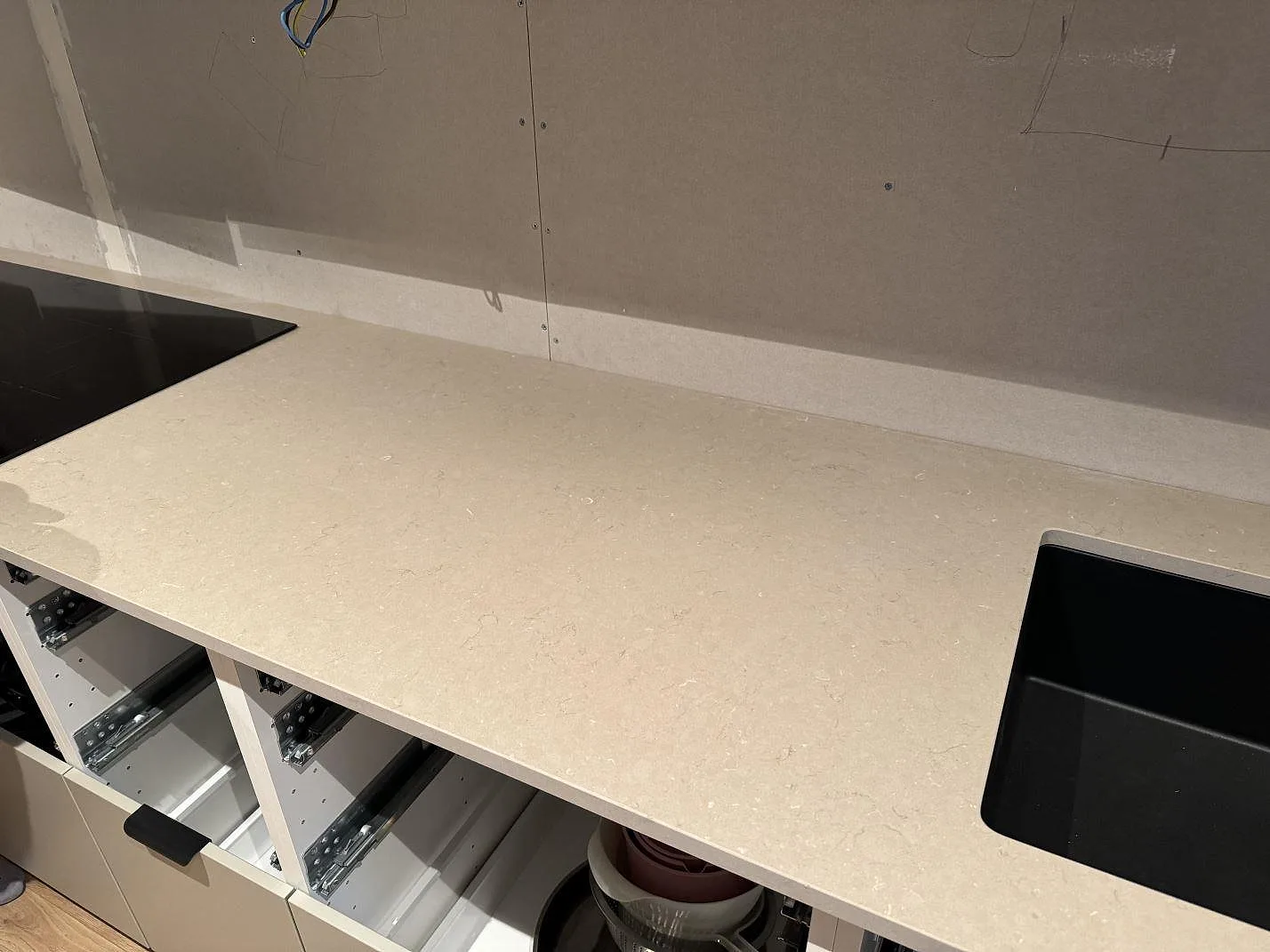 Väggbänk i matt Silestone Coral Clay med svart diskho, häll och uppvikt stänkkant i Trollhättan.