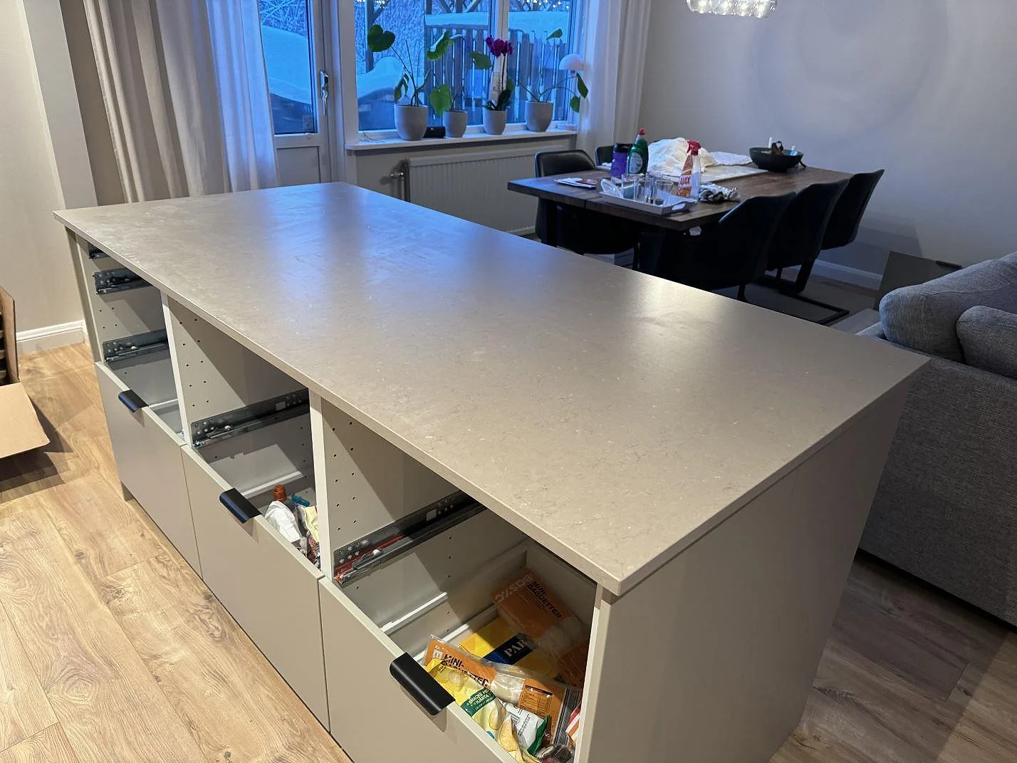 Stor köksö med matt Silestone Coral Clay i gråbeige komposit i ett öppet kök i Trollhättan.