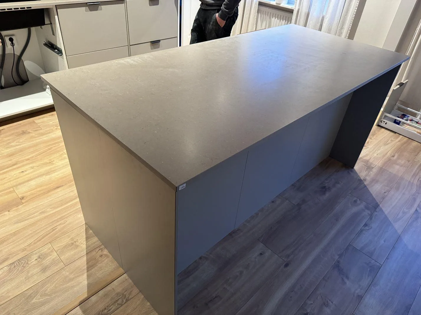 Köksö i matt Silestone Coral Clay med varm gråbeige yta och trägolv i Trollhättan.