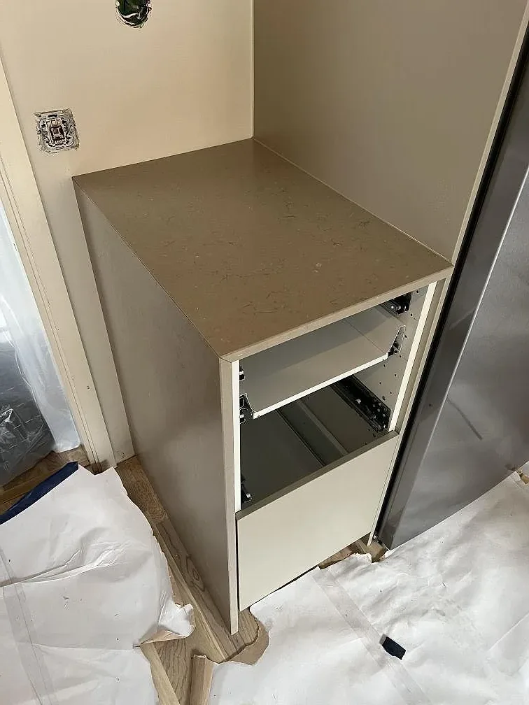 Detalj av installerad köksbänkskiva och stänkskydd i Silestone Coral Clay, matt komposit i Mocka, under montering i Tyresö.