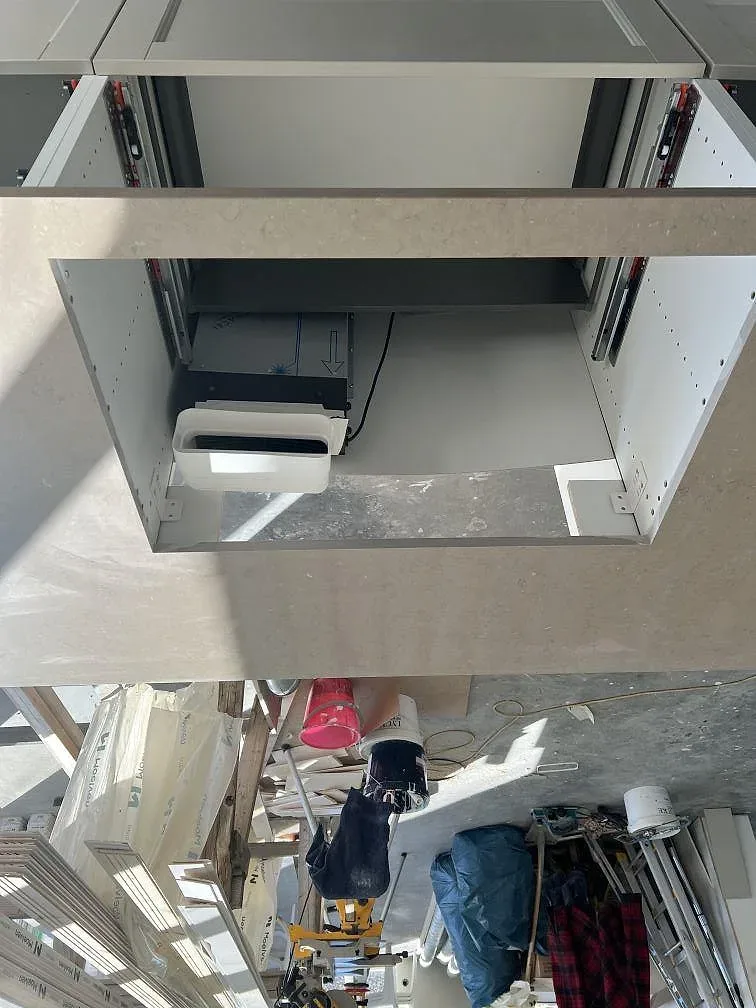 Köksbänkskiva i Silestone Coral Clay med urtag för svart diskho och öppna köksstommar i Ucklum.