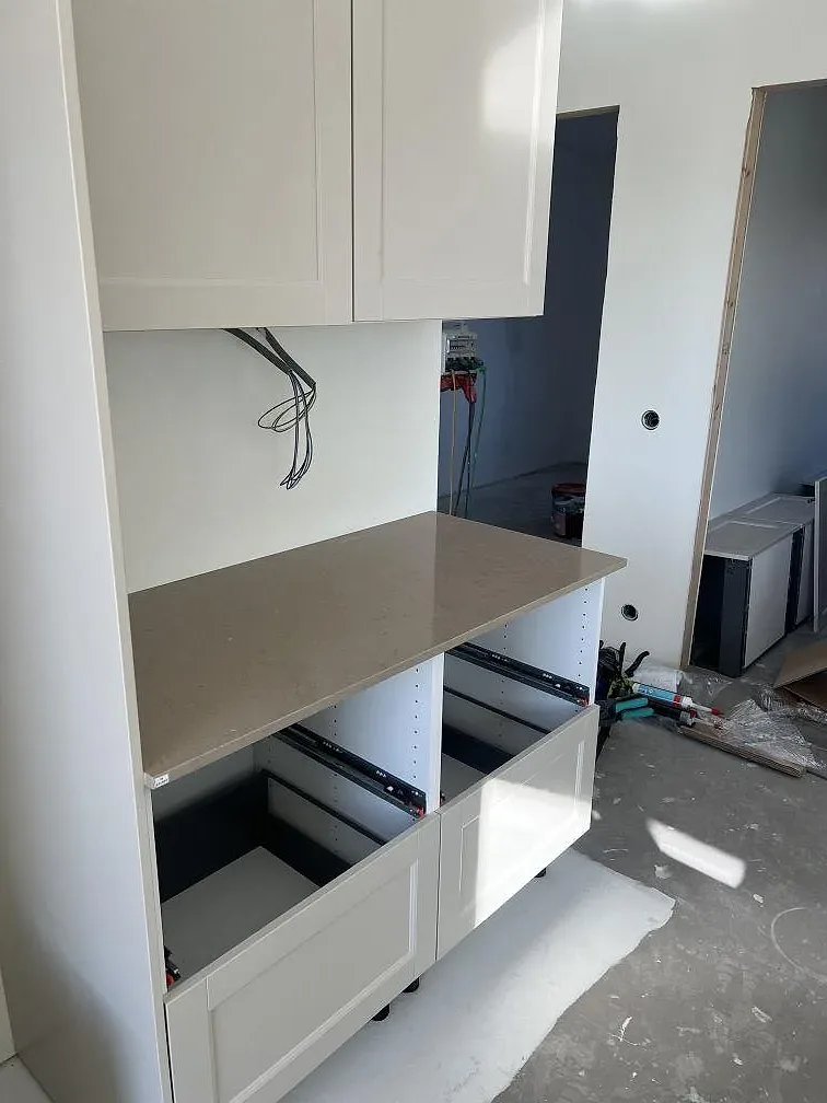 Polerad köksbänkskiva i Silestone Coral Clay på en köksrad med vita stommar i Ucklum.