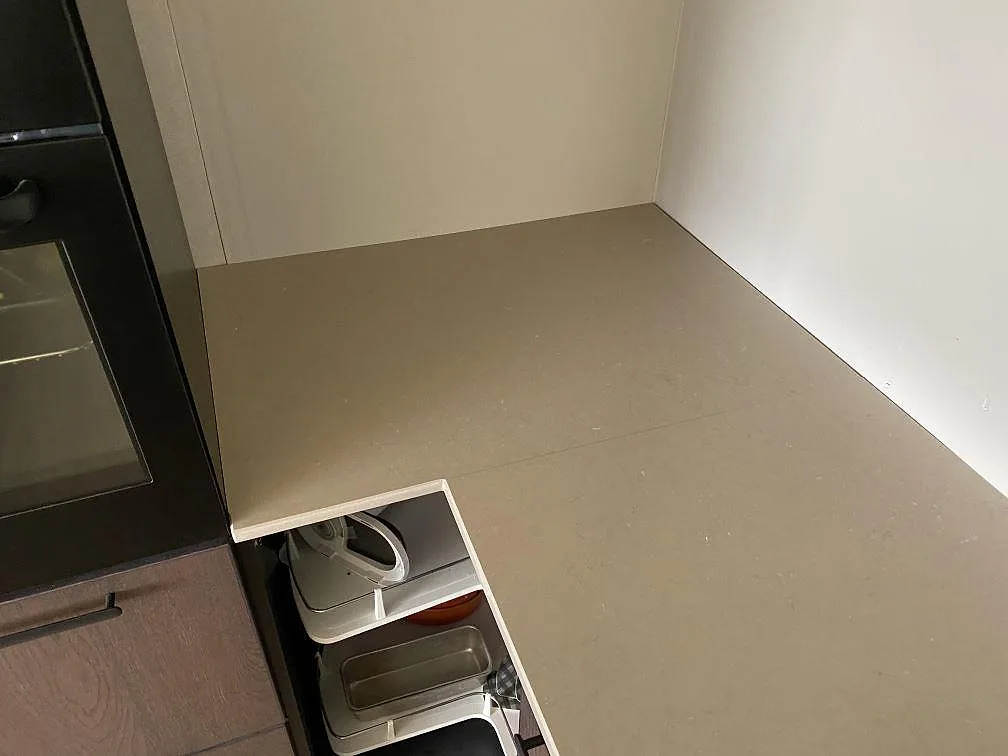 Polerad Silestone Coral Clay bänkskiva som vänder runt ett hörn i ett kök under montering i Uddevalla.