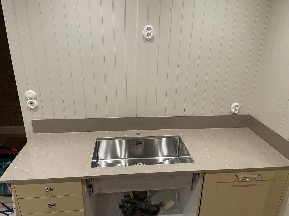 Polerad bänkskiva i Silestone Coral Clay med underlimmad rostfri diskho i ett kök under montering i Västerås.