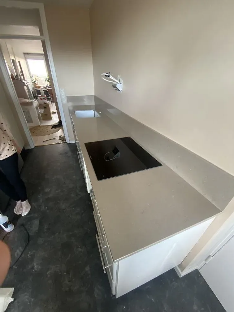 Köksbänk i polerad Silestone Coral Clay med diskho och induktionshäll i ett kök under montering i Västra Frölunda.
