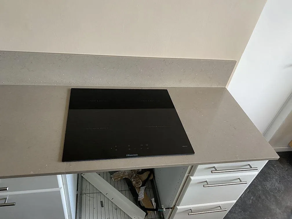 Bänkskiva i Silestone Coral Clay med induktionshäll och öppen köksstomme under pågående montering i Västra Frölunda.