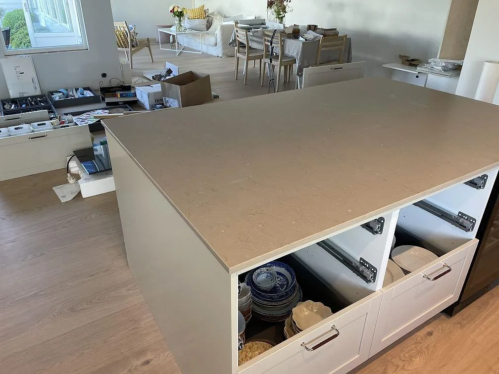 Stor köksö i Silestone Coral Clay, matt kvartskomposit, med vita skåp och öppen matplats i Västra Frölunda.