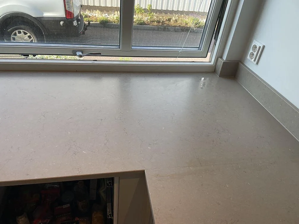 Bänkskiva i Silestone Coral Clay framför köksfönster med matt yta och uppvikt stänkkant i Västra Frölunda.