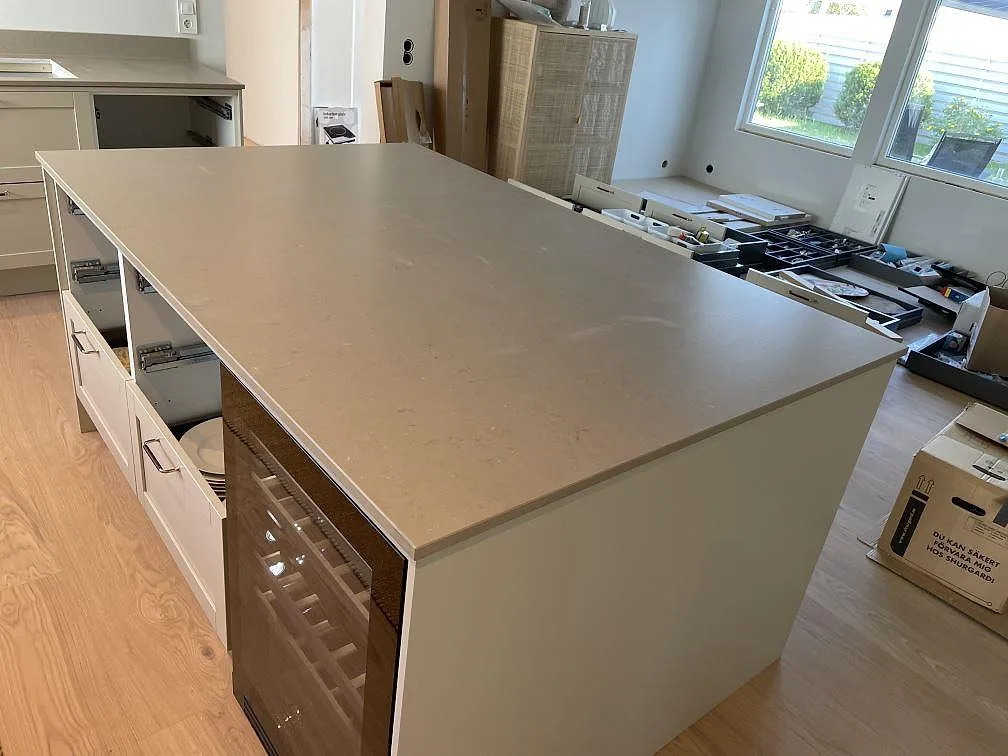 Köksö i Silestone Coral Clay med matt yta, integrerad vinkyl och synliga monteringsdetaljer i Västra Frölunda.