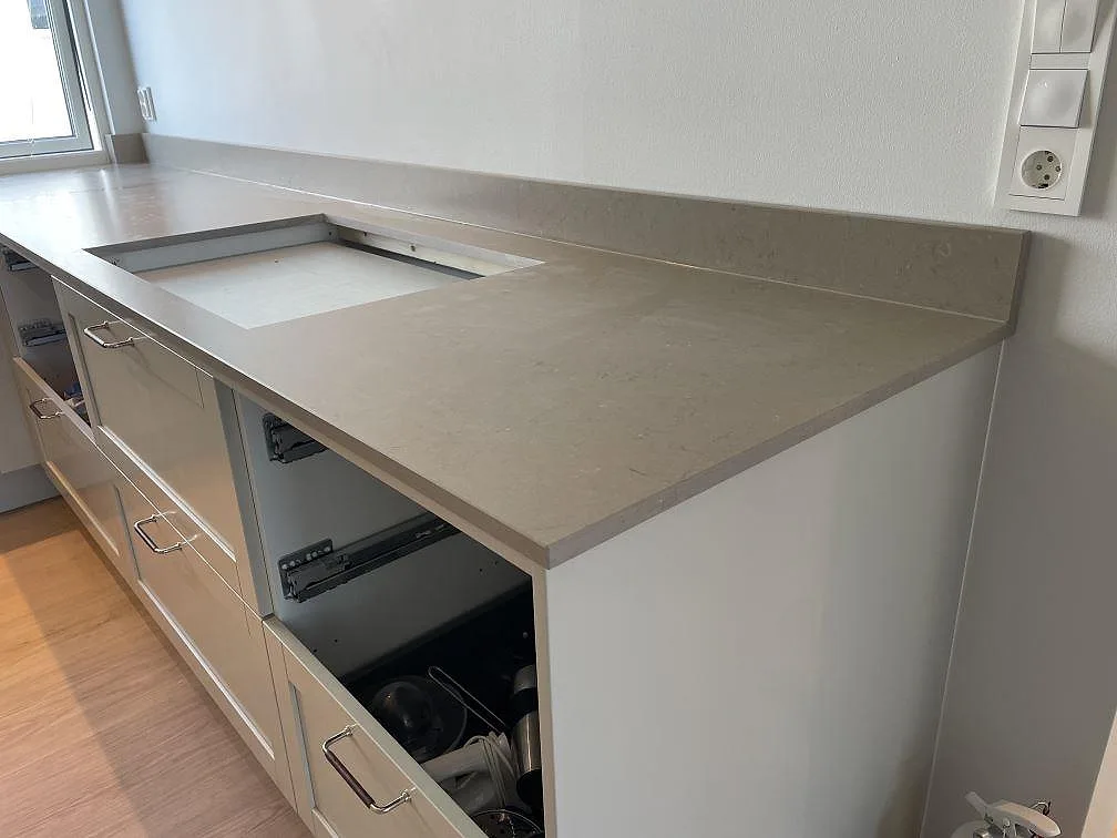 Silestone Coral Clay bänkskiva i kök med uppvikt stänkkant och hälluttag under montering i Västra Frölunda.