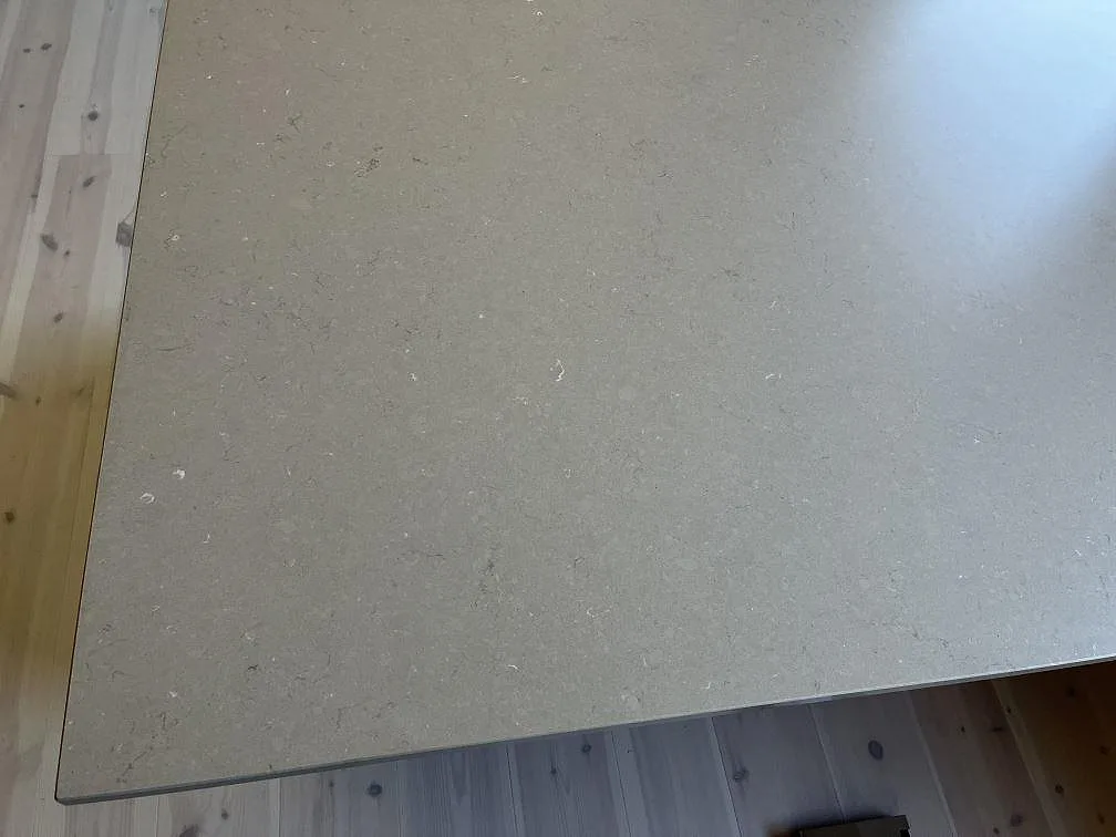 Topp av köksö i Silestone Coral Clay, matt greige kvartskomposit över trälucksstommar i ett kök i Växjö.