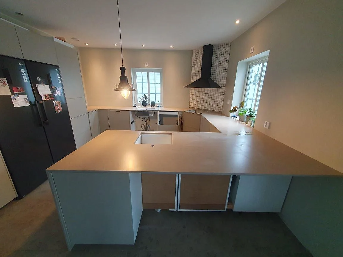 Köksbänkskiva och köksö i Silestone Coral Clay komposit, 20 mm Mocka, i ett kök under montering i Vallentuna.