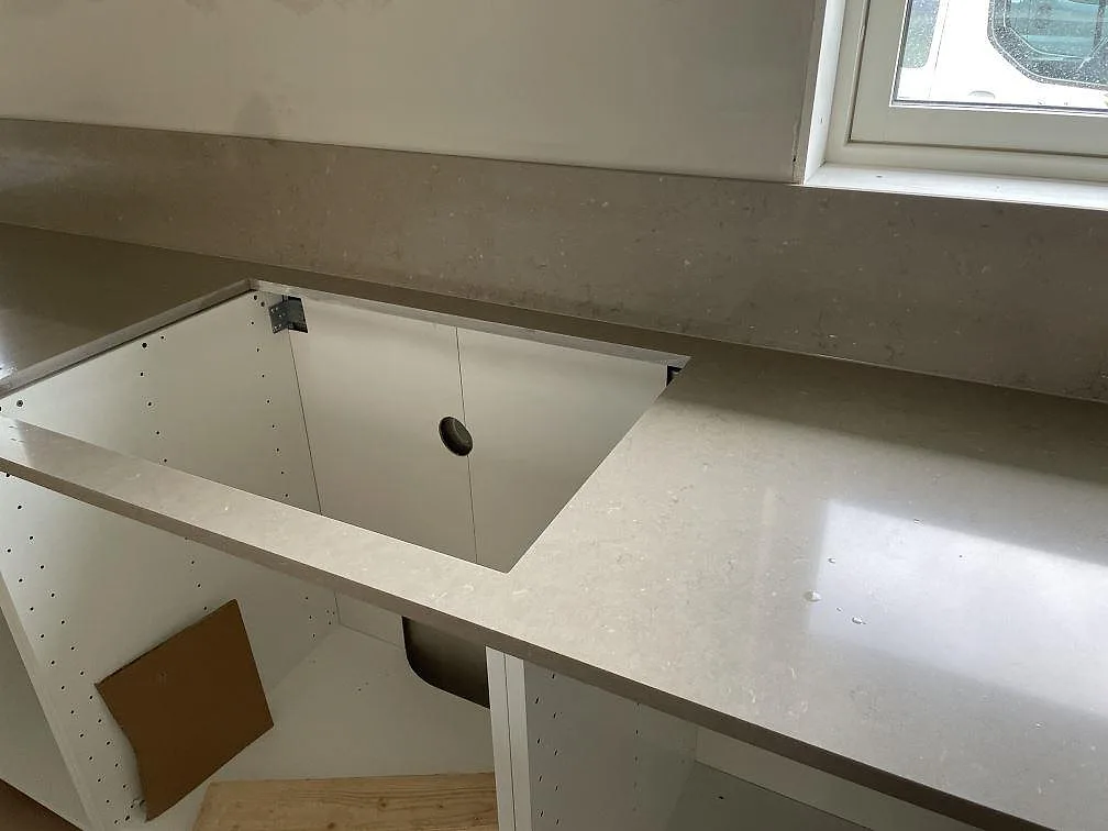 Detalj av polerad Silestone Coral Clay runt stor urtagning och stänkkant i Varberg.