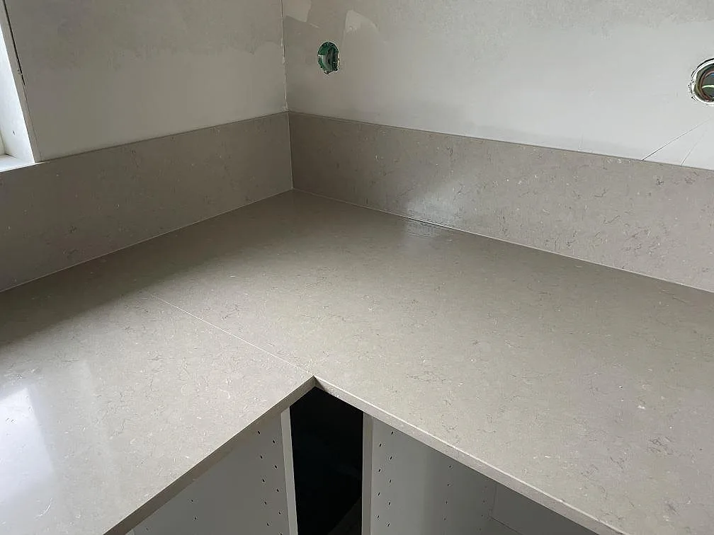 Närbild på hörn i polerad Silestone Coral Clay med matchande stänkkant i kök i Varberg.