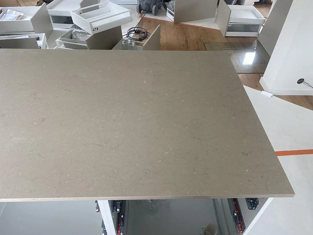 Frilagd köksö i polerad Silestone Coral Clay sedd uppifrån i ett kök under montering i Vellinge.