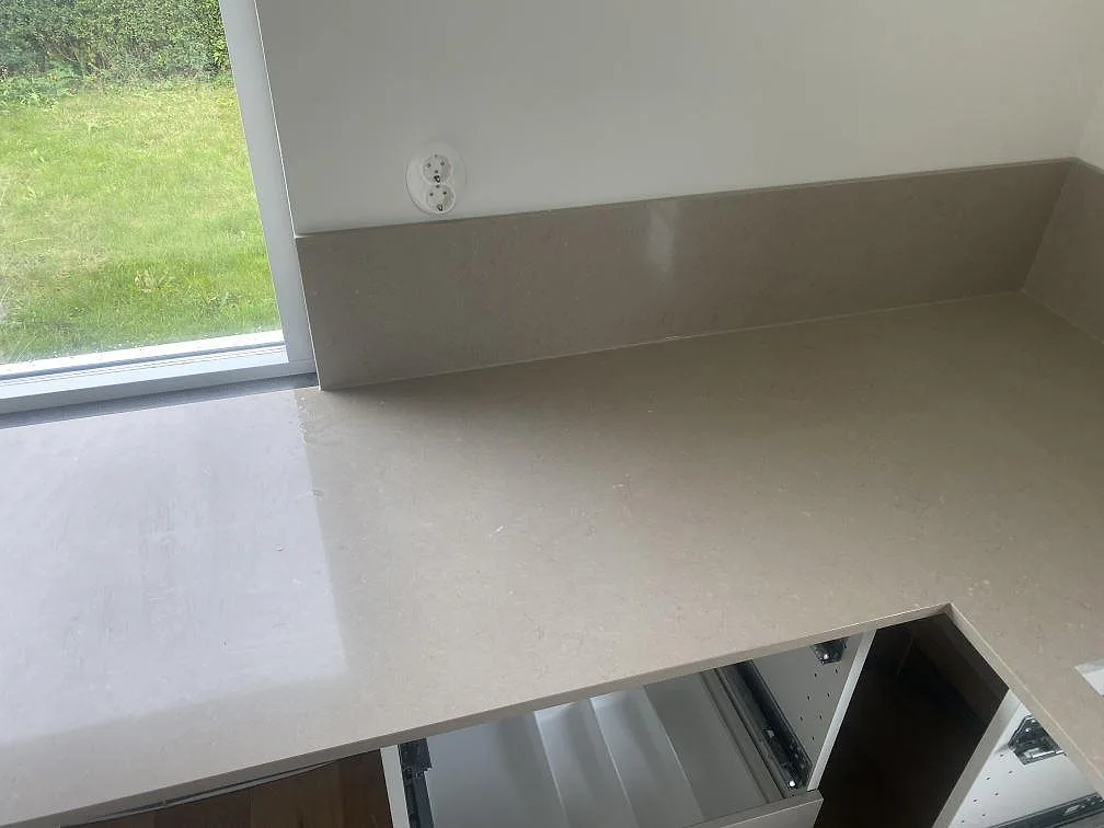 Hörn av köksbänkskiva i Silestone Coral Clay med låg uppvikt stänkkant i samma sten i ett kök i Vellinge.