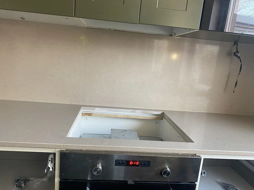 Köksbänkskiva i Silestone Coral Clay med urtag för induktionshäll och stänkskydd i samma greige komposit i Vellinge.