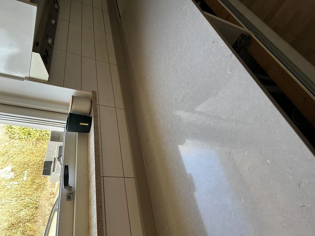 Polerad ytstruktur på en bänkskiva i greige Silestone Coral Clay kvartskomposit i ett kök i Vellinge.