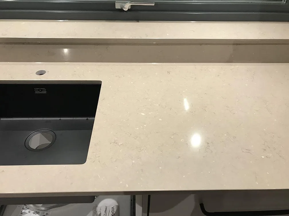 Polerad Silestone Coral Clay bänkskiva med svart underlimmad diskho och kranhål i ett kök i Vrigstad.
