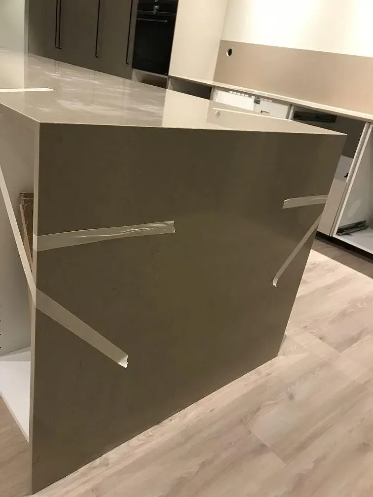 Kontrasterande köksö i polerad Silestone Marengo bredvid bänkskivorna i Coral Clay i ett kök i Vrigstad.