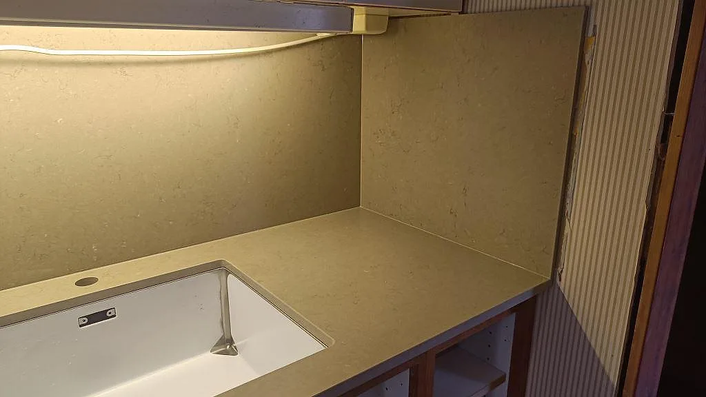 Köksbänkskiva i Silestone Coral Clay komposit med underlimmad diskho, stänkskydd och träinredning i Ystad.