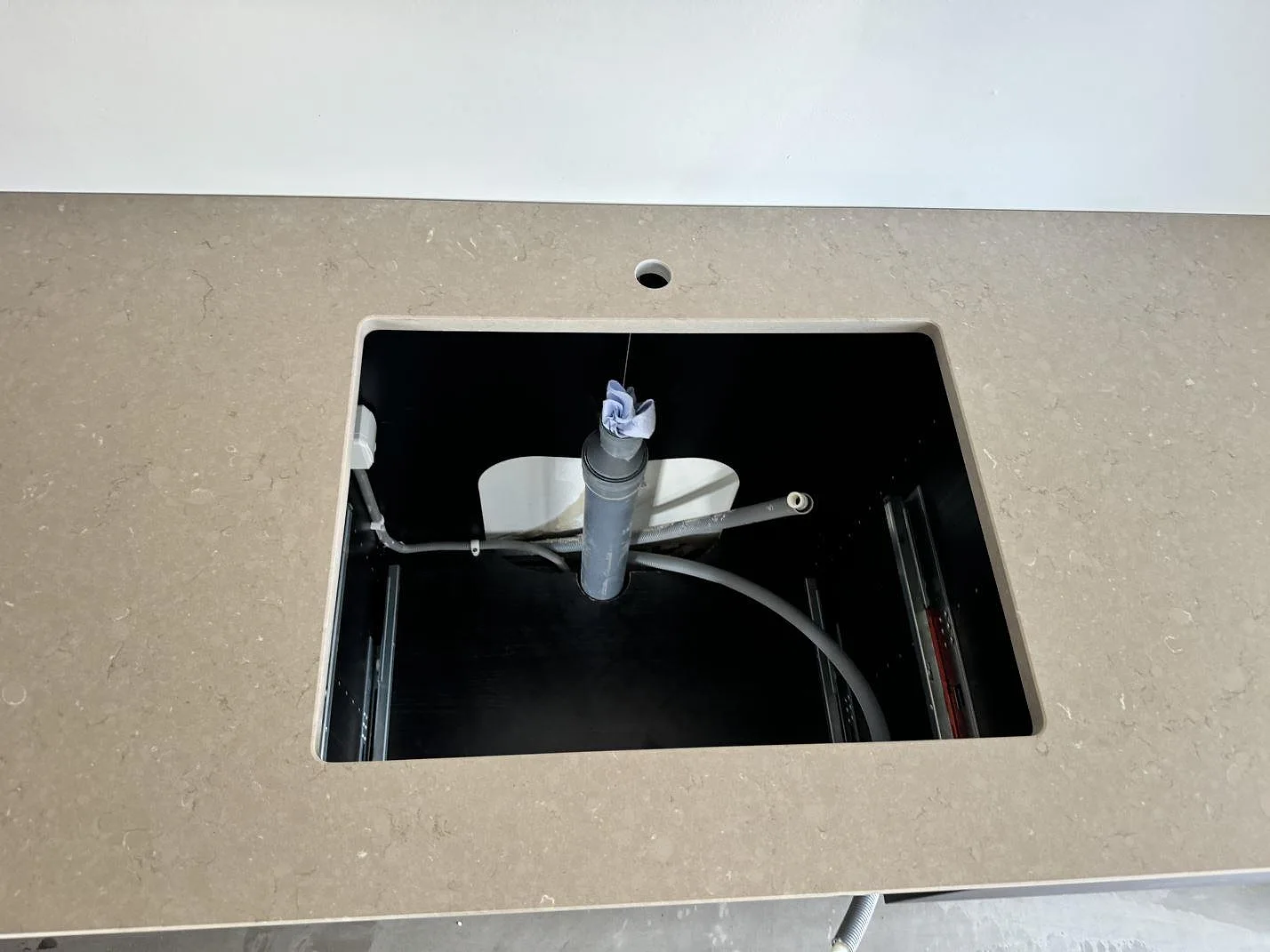 Detalj av rektangulärt urtag i 20 mm Silestone Coral Clay, Mocka, med matt gråbeige komposityta i Ystad.