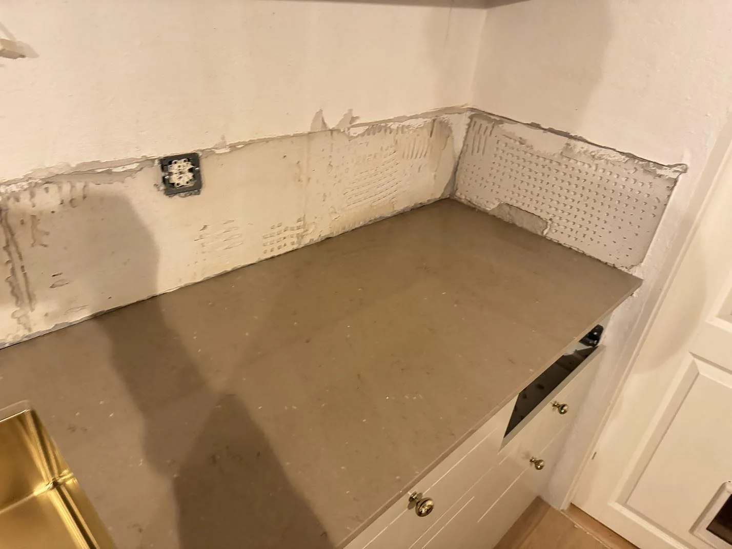 Hörndel av köksbänkskiva i polerad Silestone Coral Clay-komposit med varm gråbeige yta i Ystad.