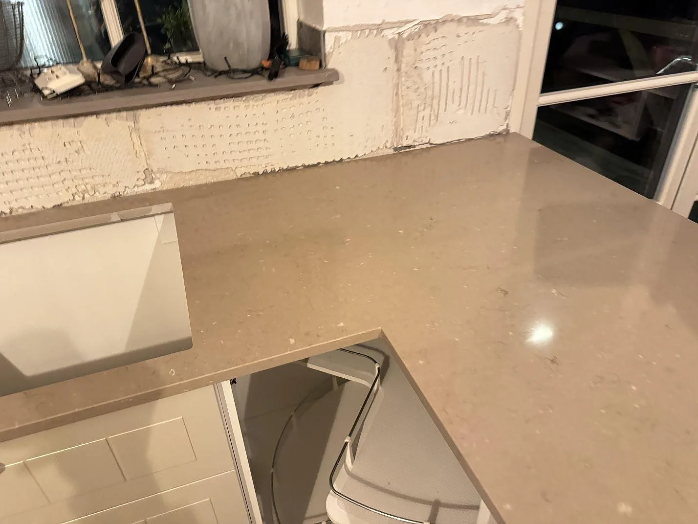Polerad Silestone Coral Clay-bänkskiva med förberett hälluttag och ljusa köksstommar i Ystad.