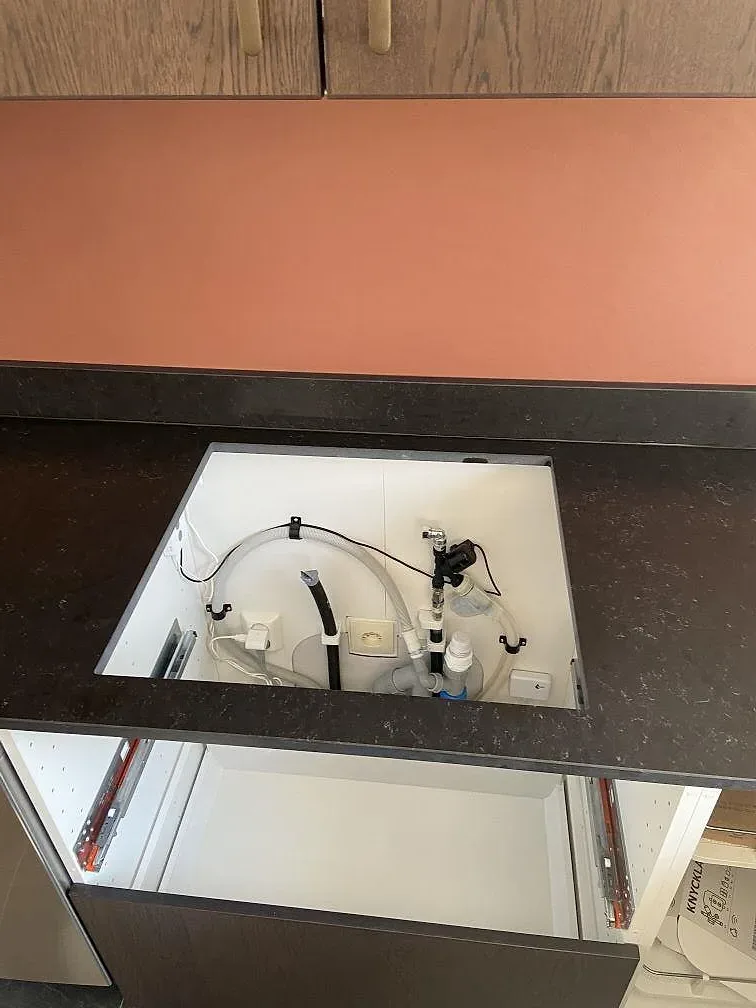 Förberedd diskhoplats i köksbänkskiva av Silestone Corktown med framdragen installation i ett kök under montering i Gråbo.