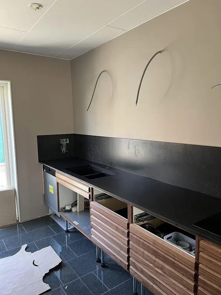 Mörk köksbänkskiva i Silestone Corktown, Mocka, med matchande stänkskydd i ett kök i Lomma.