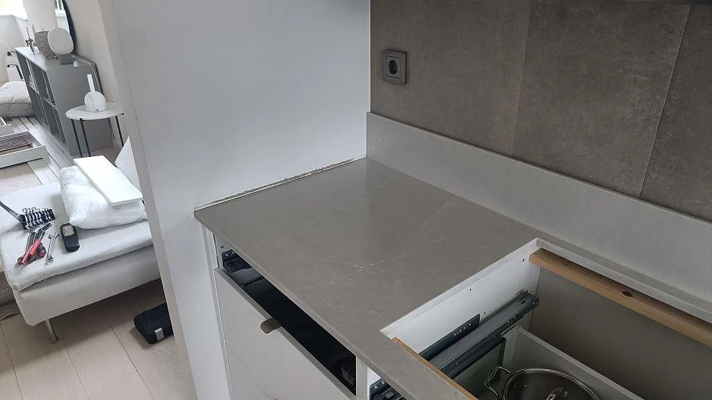 Silestone Desert Silver bänkskiva i polerad kvartskomposit vid ett rektangulärt urtag, fotograferad under köksmontering i Ängelholm.