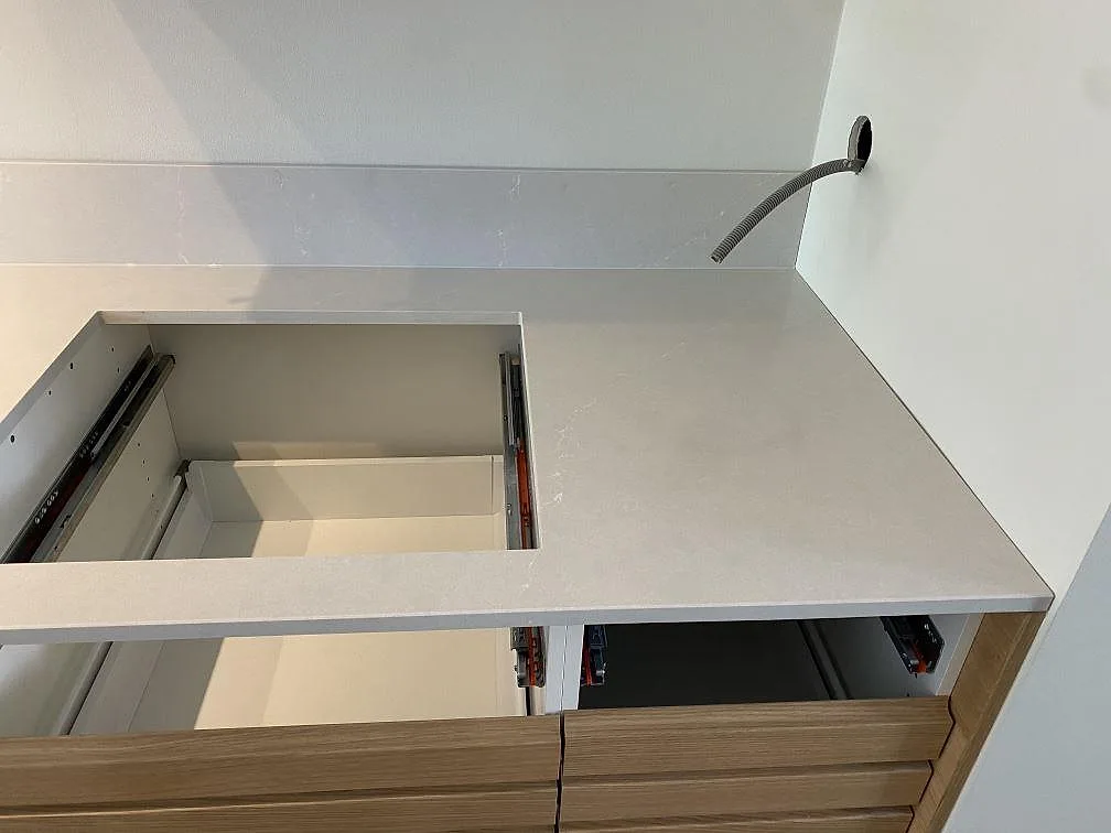Detalj av installerad Silestone Desert Silver vid öppen köksstomme, 12 mm polerad kvartskomposit med låg stänkkant i Halmstad.