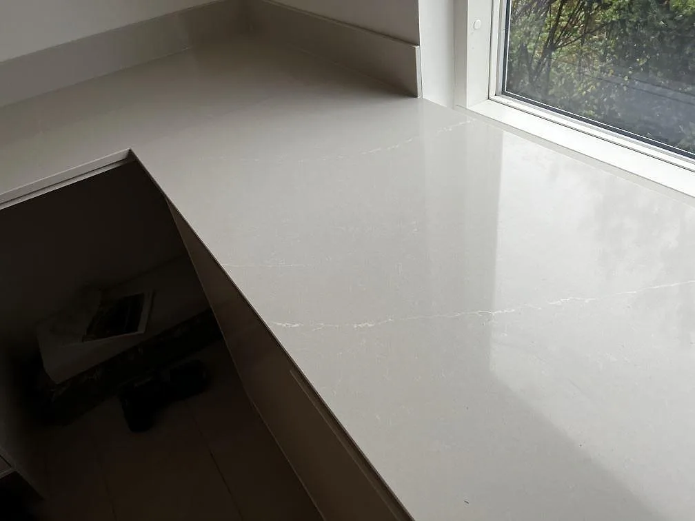 Polerad Silestone Desert Silver bänkskiva med ljus ådring och fönsterparti i ett kök i Halmstad.
