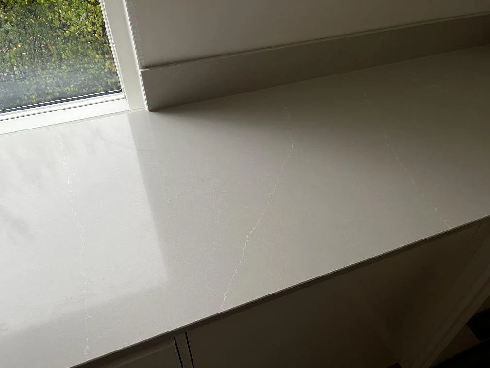 Detalj av polerad Silestone Desert Silver komposit med ljus ådring längs fönstersidan i Halmstad.