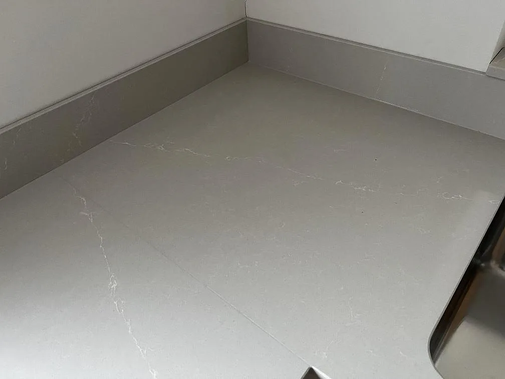 Köksbänkskiva i Silestone Desert Silver med uppvikt kant, hörnpassning och synlig diskho i Halmstad.