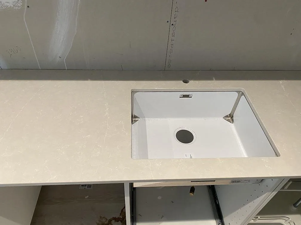 Diskho monterad under en polerad Silestone Desert Silver köksbänkskiva med diskret ådring i Höllviken.