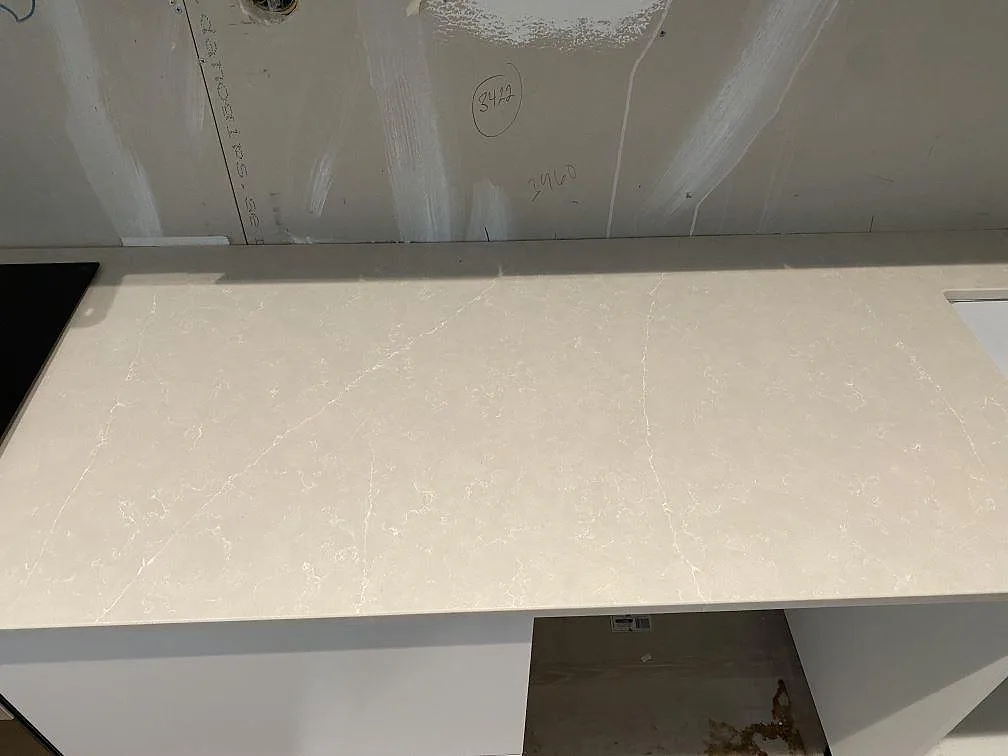 Närbild av polerad Silestone Desert Silver komposit med ljus ådring på installerad köksbänkskiva i Höllviken.