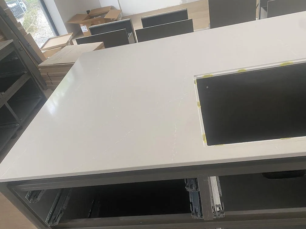 Polerad Silestone Desert Silver på köksö med rektangulärt hällurtag och öppna köksstommar i Höllviken.