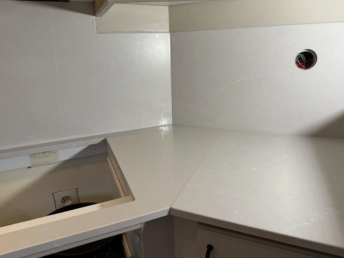 L-formad köksbänkskiva i Silestone Desert Silver, Mocka, med sinkuttag och stänkskydd under montering i Hovås.