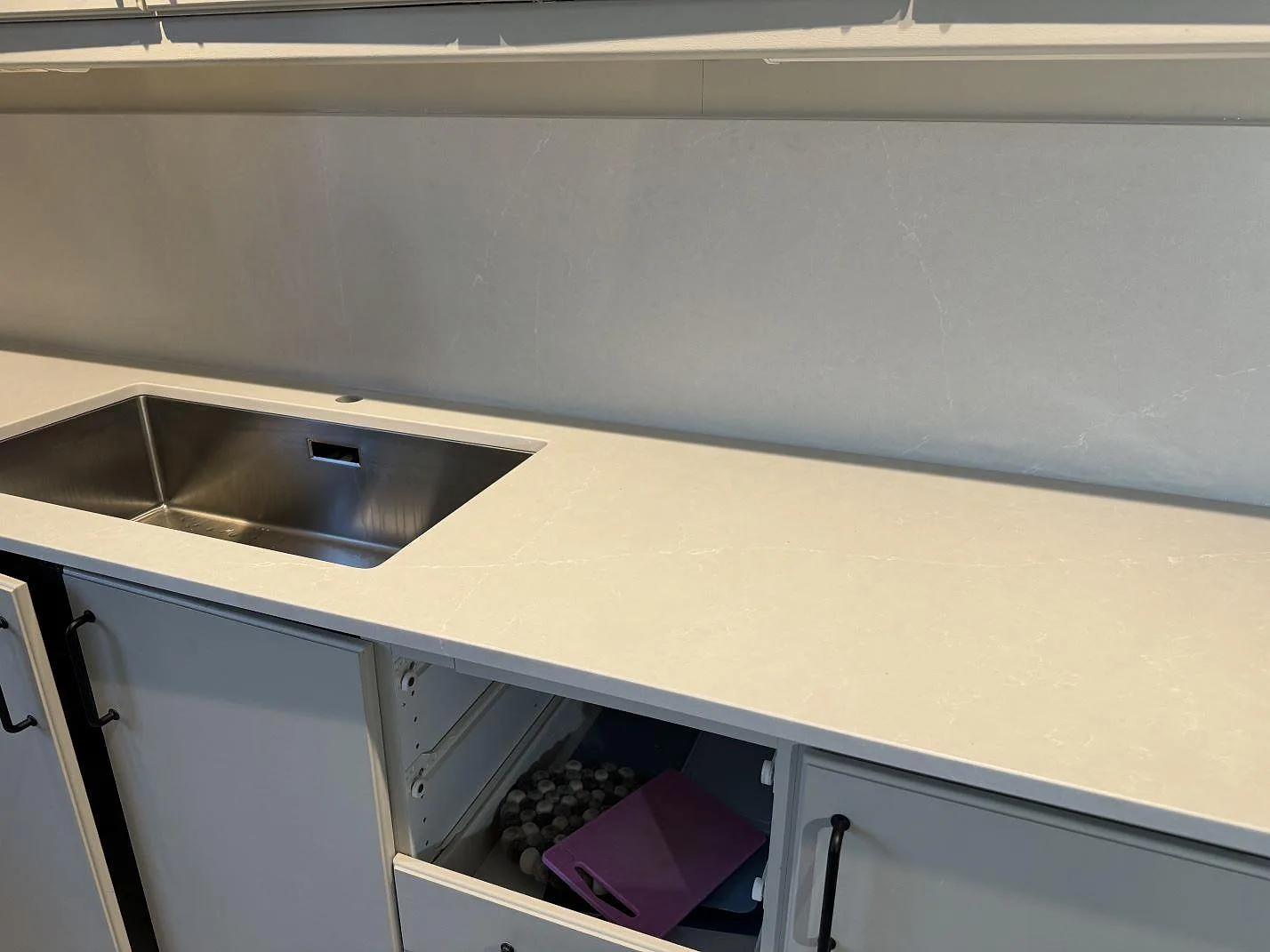 Silestone Desert Silver bänkskiva i Mocka med rostfri diskho monterad under stenen och matchande stänkskydd i Hovås.