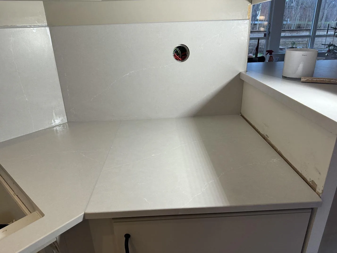 Installerad Silestone Desert Silver bänkskiva i Mocka med uppvikt stänkkant och ljus ådring i Hovås.