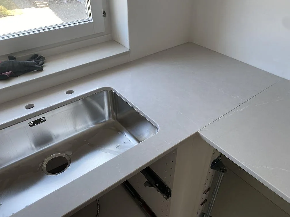 Köksbänkskiva i polerad Silestone Desert Silver med underlimmad rostfri diskho och hörnpassning i Karlshamn.