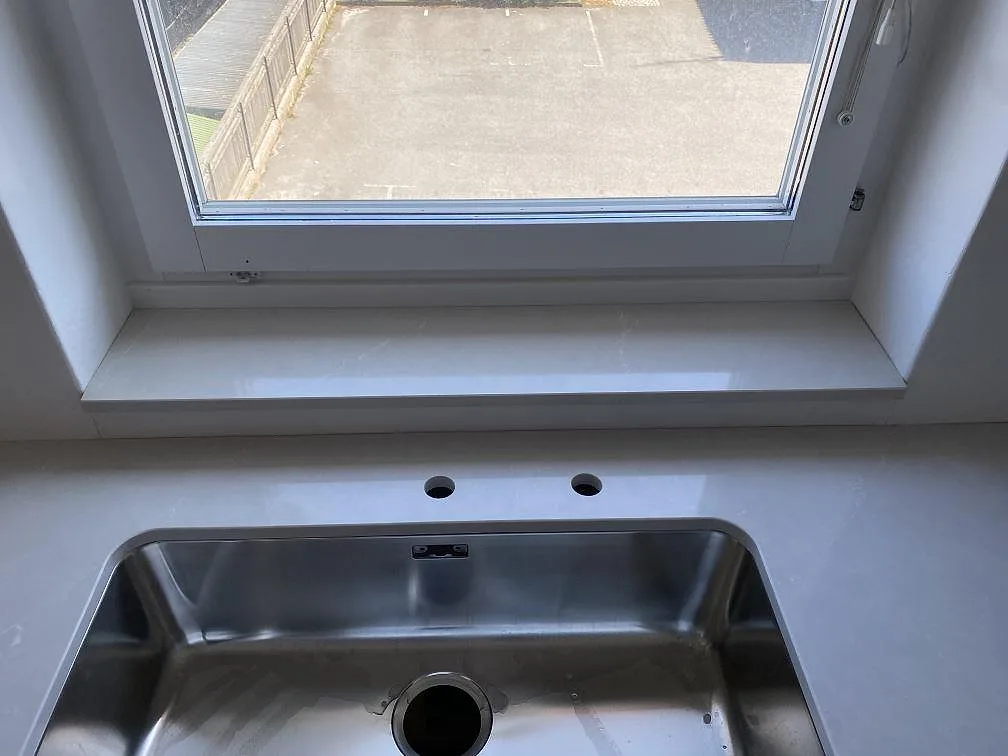 Underlimmad rostfri diskho vid fönster i en polerad Silestone Desert Silver köksbänkskiva i Karlshamn.