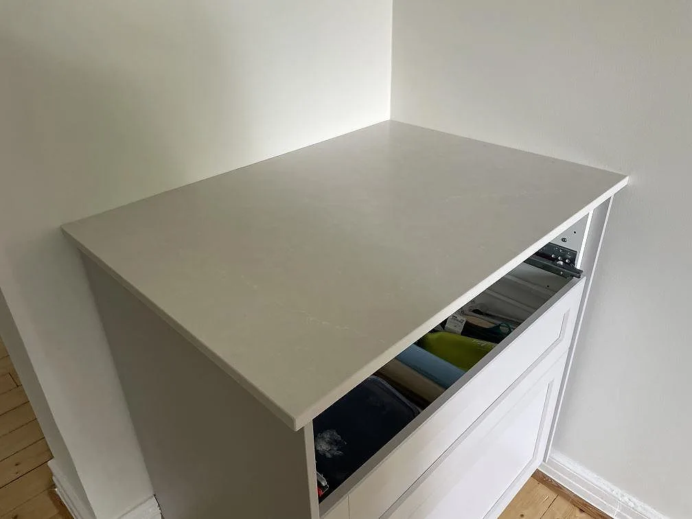Närbild på ljus Silestone Desert Silver bänkskiva i Mocka-finish över vit köksstomme i Lund.