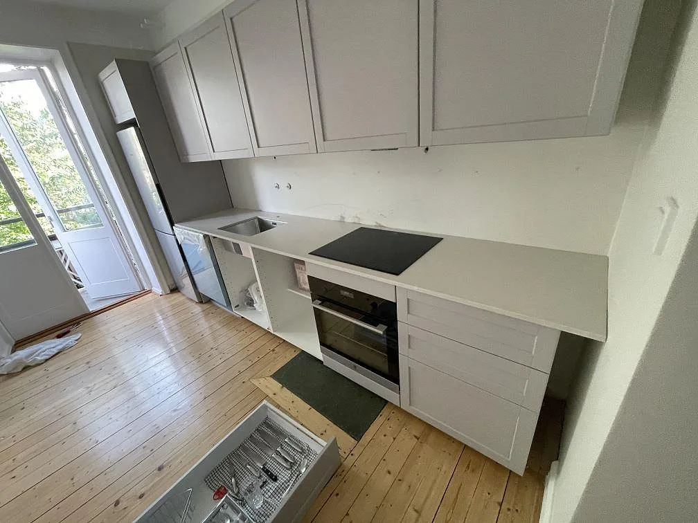 Köksbänkskiva i Silestone Desert Silver, 20 mm Mocka, med rostfri underlimmad diskho och svart induktionshäll i ett kök i Lund.