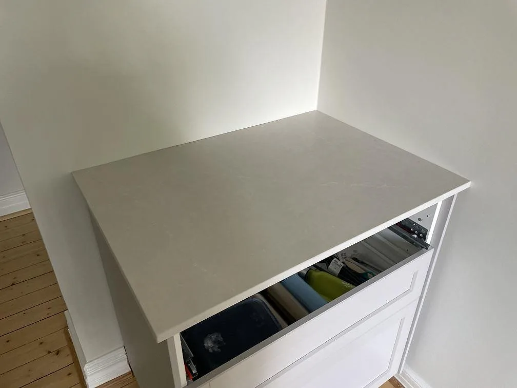 Kort bänkskiva i Silestone Desert Silver, matt Mocka, monterad på vit köksinredning i Lund.