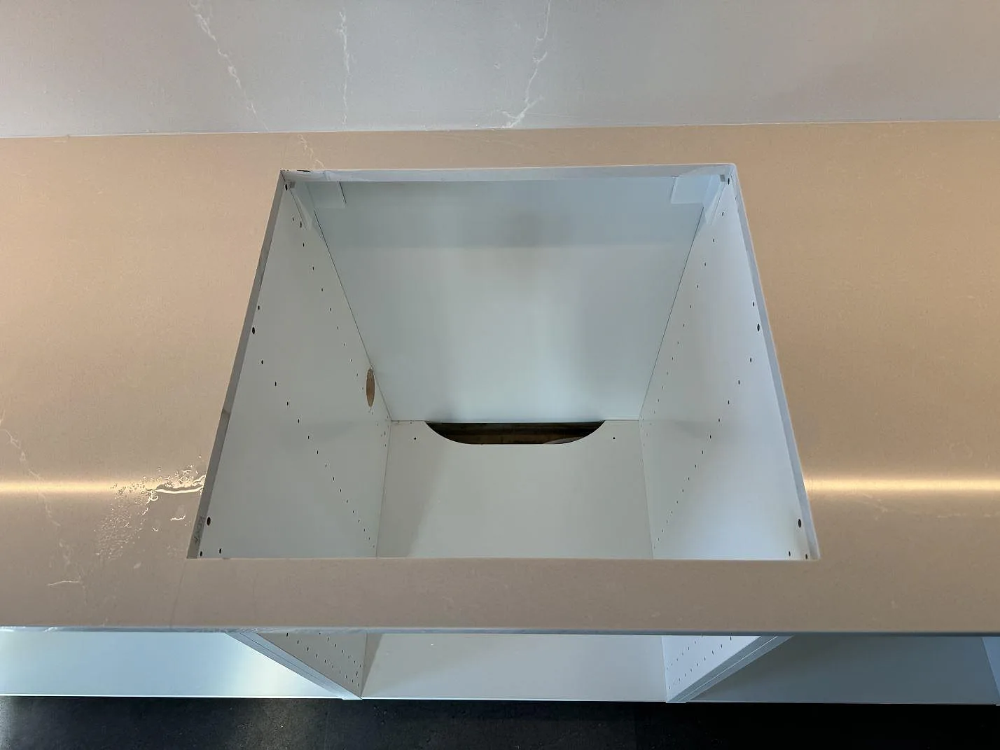 Närbild på urtag i polerad Silestone Desert Silver med stänkskydd bakom bänkskivan i ett kök i Malmö.
